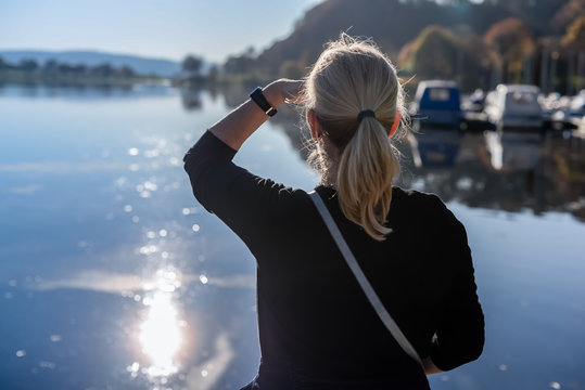 Eine Frau sieht auf einen See.