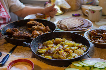 Fried potato in pan on real family table