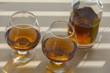 Bottle and two glasses of brandy.