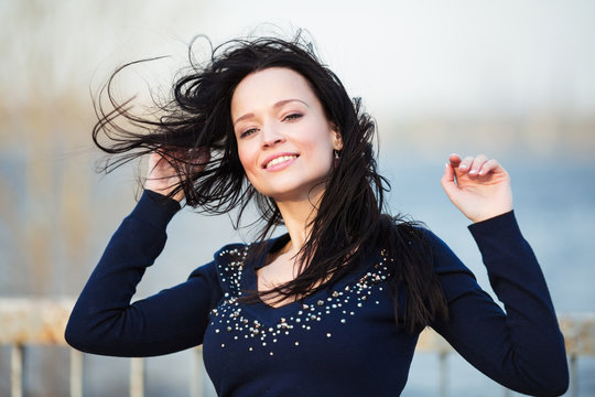 Smiling Girl With Long Black Hair Blowing By Wind