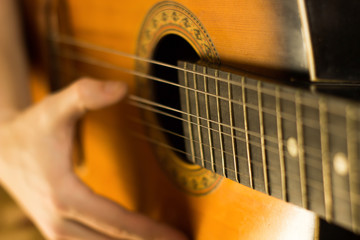 Young guy playing on guitar. Hand and guitar close-up.Soft and blur conception