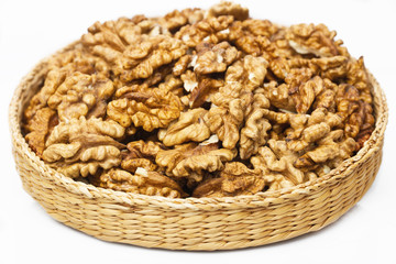 Fresh walnuts  of a wicker basket on  white background