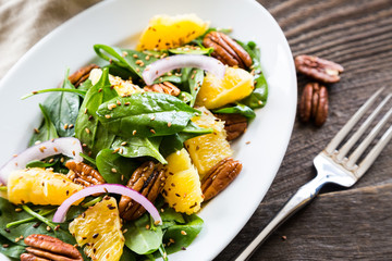 Salad with fresh spinach, oranges and pecan