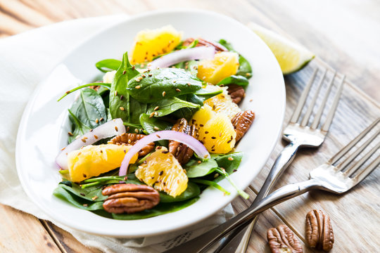 Salad with fresh spinach, oranges and pecan