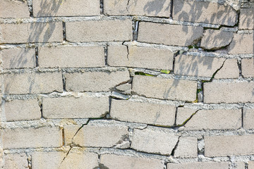 closeup of dangerous wall with cracks in sunshine