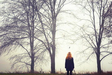 Blonde woman on walk.Autumn wood. Fog background. Quiet landscape.