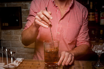 Bartender is stirring cocktails on bar counter