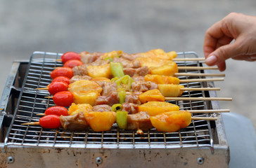 Meat and vegetable skewer on barbecue grill with fire