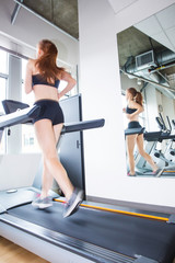 Fototapeta na wymiar strong woman running on treadmill in gym