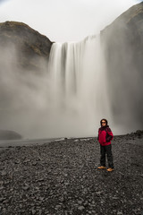 woman tourist standing in front of the waterfall