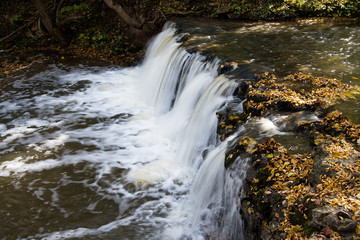 Fototapeta na wymiar Small waterfall in autumn.