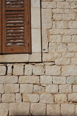 Muro in pietra viva squadrata e porzione di finestra.