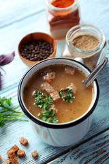 Mug of soup on blue wooden background