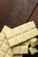 White chocolate pieces on wooden background