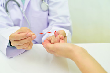 Medical technologist collect blood sample from patient finger
