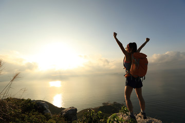 Naklejka premium doping młoda kobieta backpacker na wschód słońca nadmorski szczyt