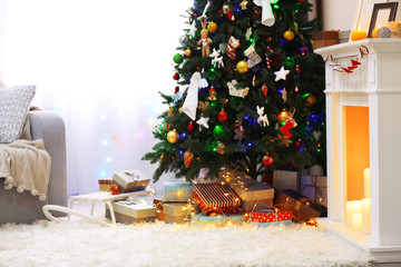 Decorated room with Christmas tree and presents under it, close up