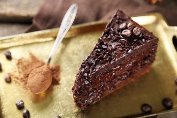 Chocolate cake with chocolate cream on tray, on wooden background