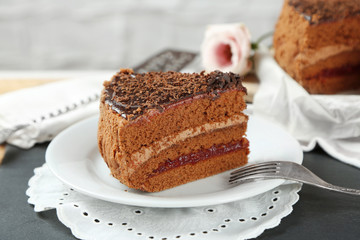 Sliced chocolate cake on plate, on wooden table  background