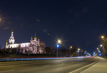 Fototapeta premium View of the night city with tram tracks and church