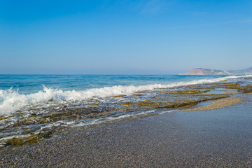 Waves breaking on a stony beach, forming sprays