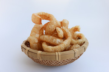 Crispy Pork Skin , Thai style food  in a wicker basket isolated over the white background 