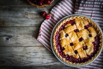 Homemade cherry pie on rustic background
