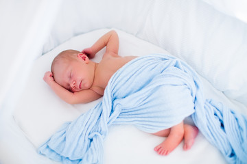 Cute newborn baby in white bed