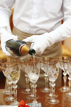 waiters in white gloves poured champagne glasses on the table