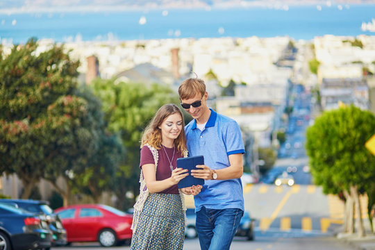 Romantic couple of tourists using tablet in San Francisco, California, USA