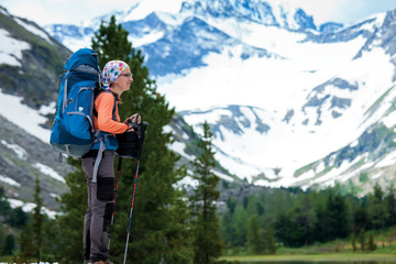 Young woman is hiking in highlands of Altai mountains, Russia