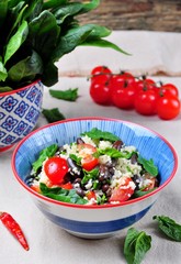 Couscous salad and brown beans, with olive oil, with organic cherry tomatoes, onion, parsley and spinach
