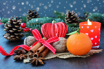 Christmas background with fruits, spices, fir, candle and snowfall