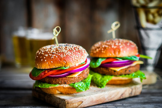 Homemade burgers on rustic wooden background