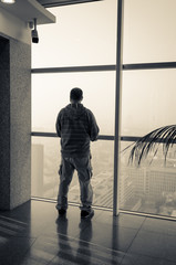 Fototapeta premium man looking through window