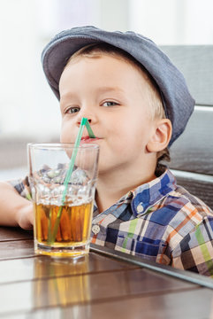 Portrait of happy little boy drinking  juice