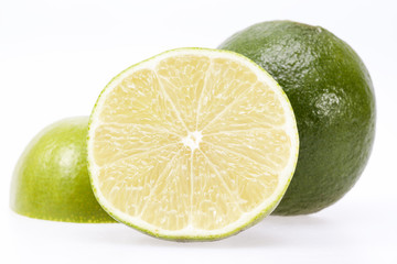 pieces of fresh green fruit of lime on white background