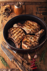 Grilled pork chop with spices in a frying pan