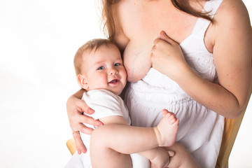 Mom feeds the baby breast, light background
