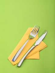 Fork and knife on green background