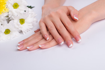 Obraz na płótnie Canvas Beautiful french manicure with white daisies.