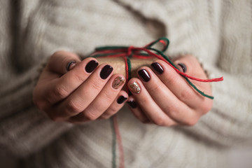 girl holding a gift box. Manicure gel nail