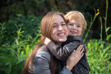 Happy son embracing his mother in nature.