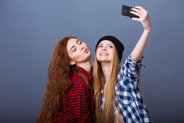 Two young women taking selfie with mobile phone