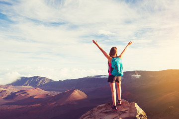 Happy Woman Hiker With Open Arms at Sunset on Mountain Peak