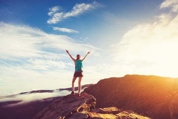 Happy Woman Hiker With Open Arms at Sunset on Mountain Peak