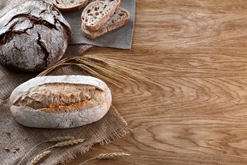 Assortment of baked bread on wooden background