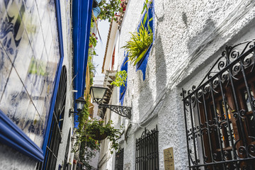 ancient, traditional Andalusian streets with flowers and white h