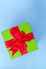 A green gift with a red ribbon and a bow