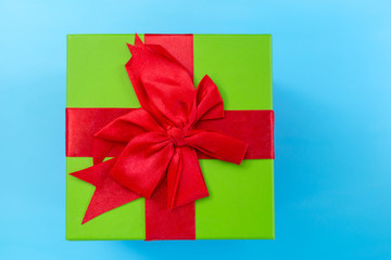 A green gift with a red ribbon and a bow